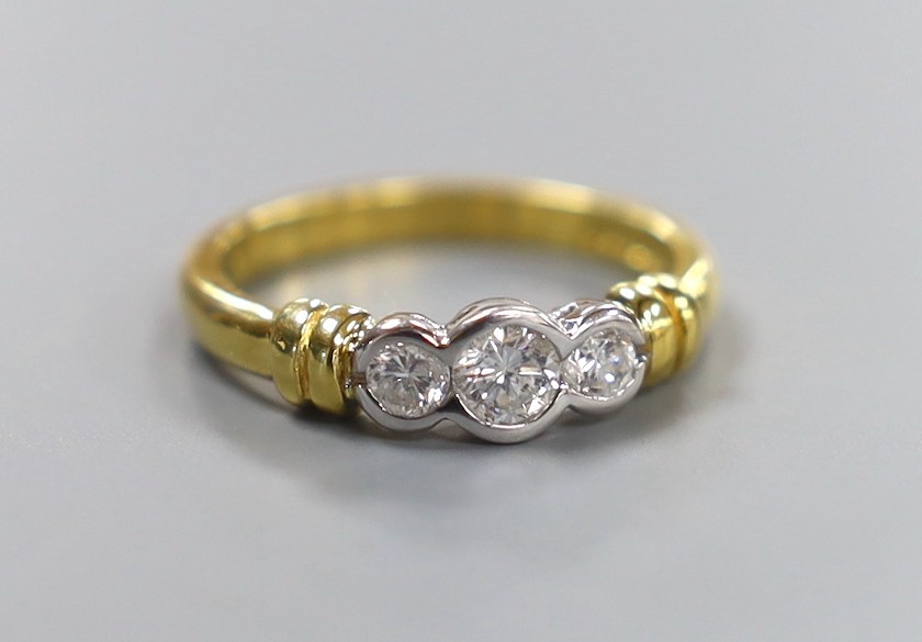 A modern 18ct gold and collet set three stone diamond ring, size O, gross weight 4.6 grams